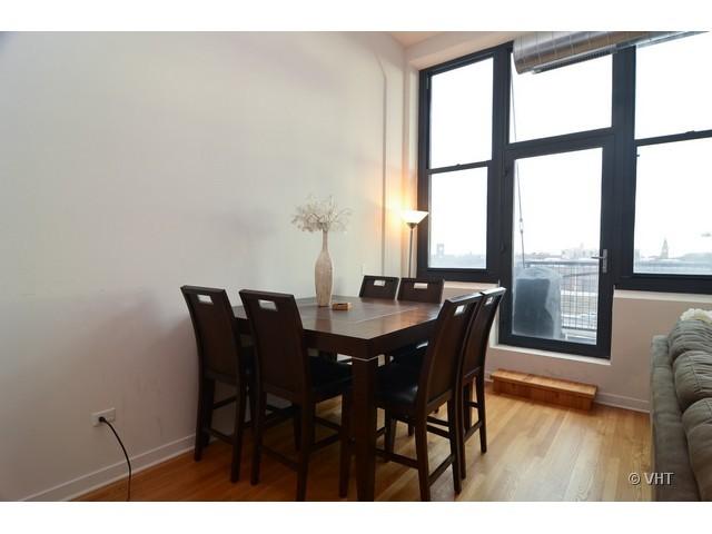1224 West Van Buren Street, Unit 802 Chicago, IL 60607 - Photo 5 of 10 a view of a dining room with furniture and wooden floor