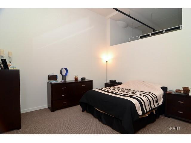 1224 West Van Buren Street, Unit 802 Chicago, IL 60607 - Photo 7 of 10 a bedroom with a bed and a desk