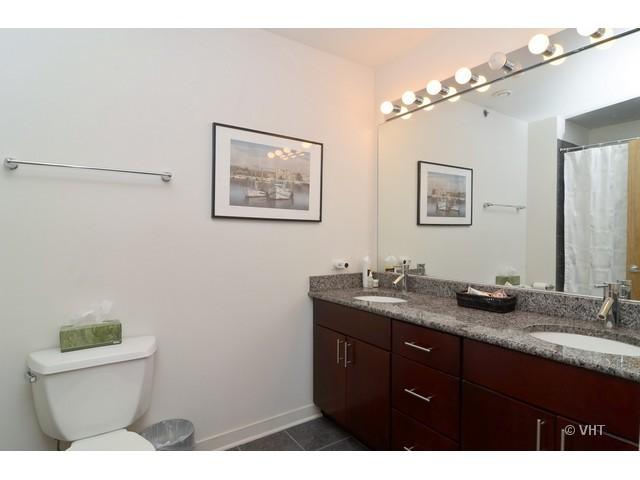 1224 West Van Buren Street, Unit 802 Chicago, IL 60607 - Photo 8 of 10 a bathroom with a granite countertop sink mirror and toilet