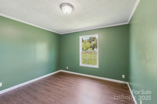 an empty room with wooden floor and a window