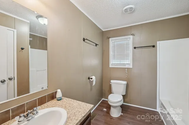 a bathroom with a toilet a sink and a mirror