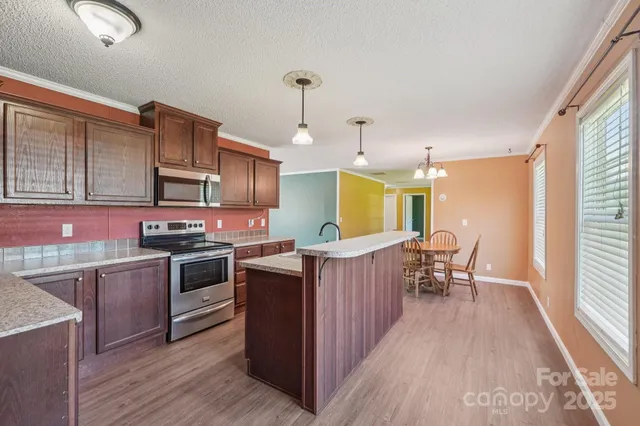 a kitchen with granite countertop a sink stove and refrigerator
