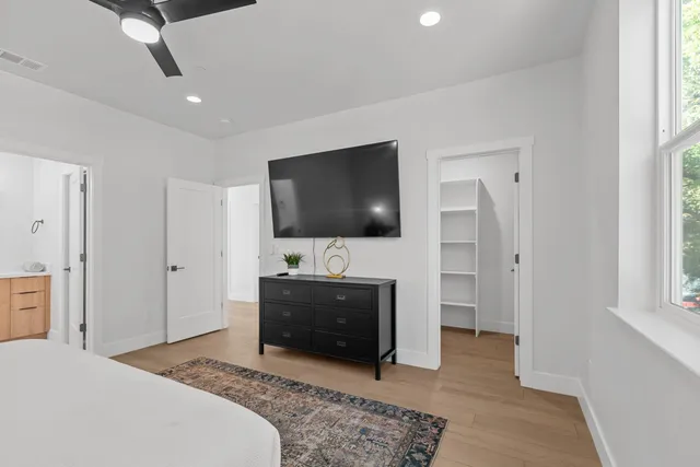 a spacious bedroom with a bed and a flat screen tv