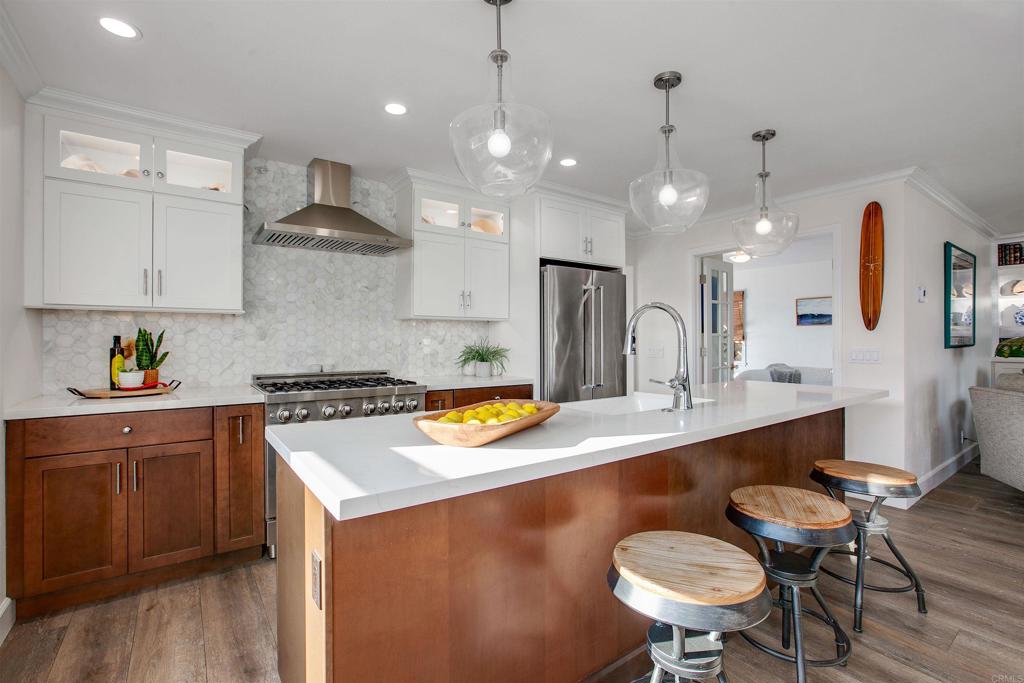 906 Leonard Avenue Oceanside, CA 92054 - Photo 12 of 53 a kitchen with a sink a stove and chairs with wooden floor
