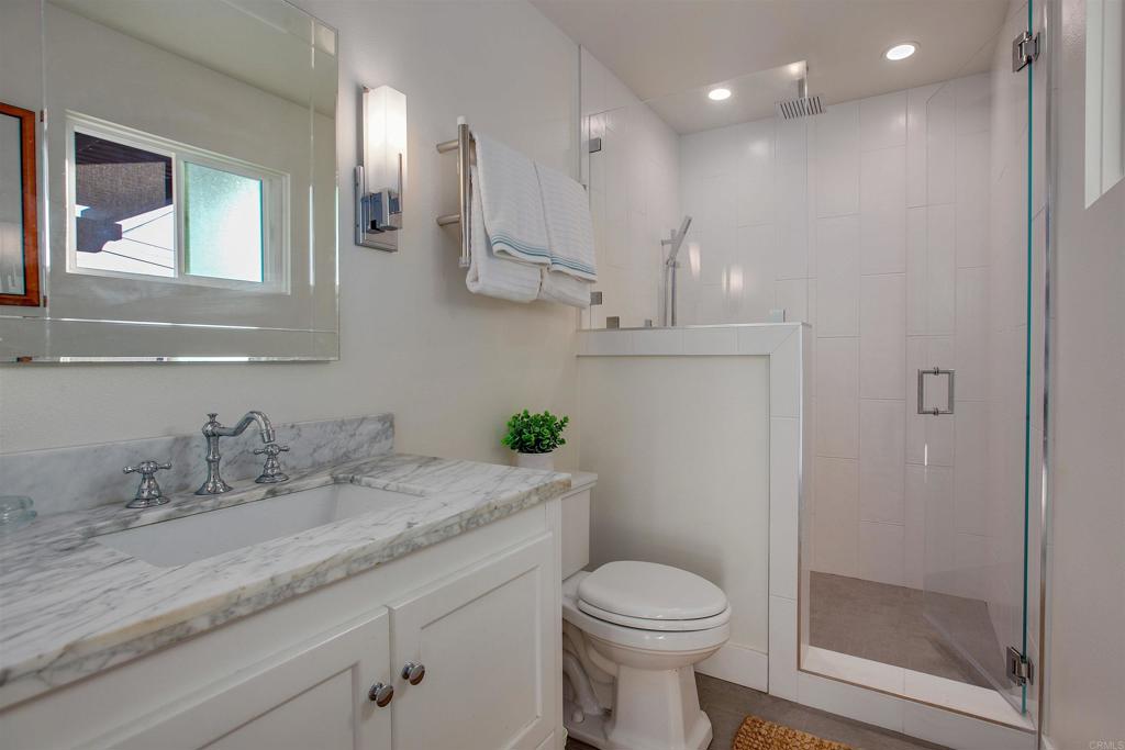 906 Leonard Avenue Oceanside, CA 92054 - Photo 17 of 53 a bathroom with a granite countertop sink a toilet and a mirror