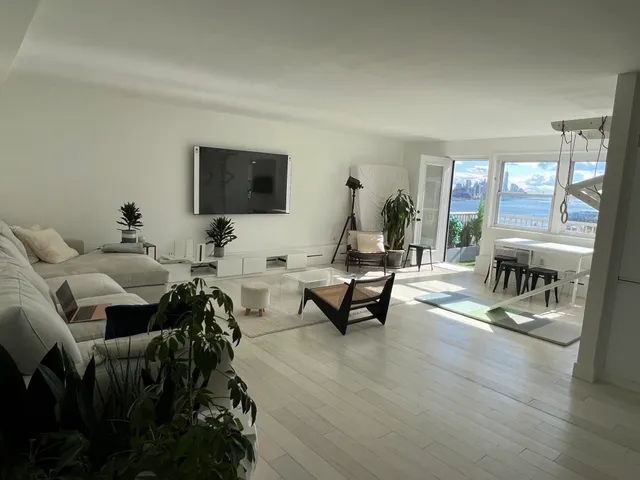 a living room with furniture and a flat screen tv with wooden floor