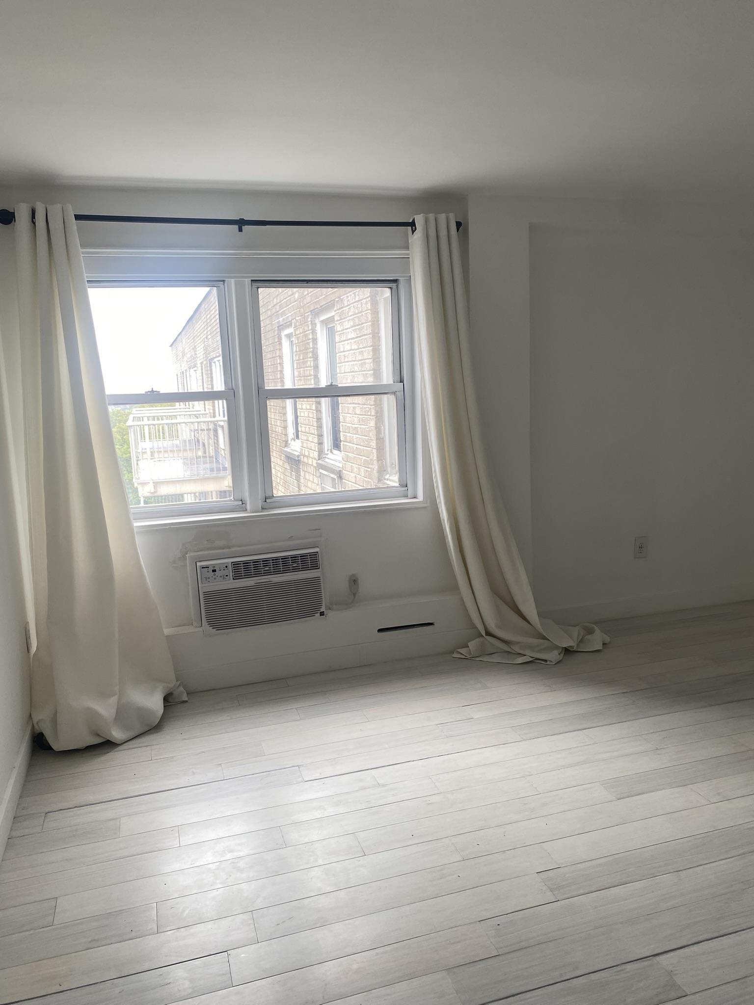 6010 Boulevard East West New York, NJ 07093 - Photo 11 of 27 an empty room with wooden floor and windows