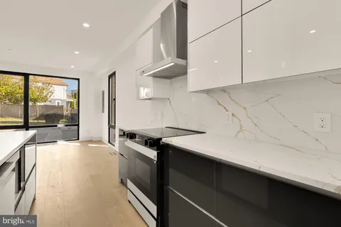 a kitchen with granite countertop a sink a stove top oven a counter space and cabinets