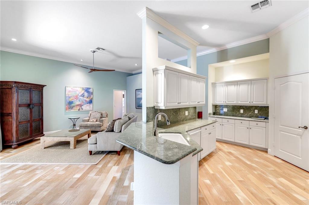 302 Sawgrass Court Naples, FL 34110 - Photo 11 of 40 a large white kitchen with lots of counter top space and stainless steel appliances