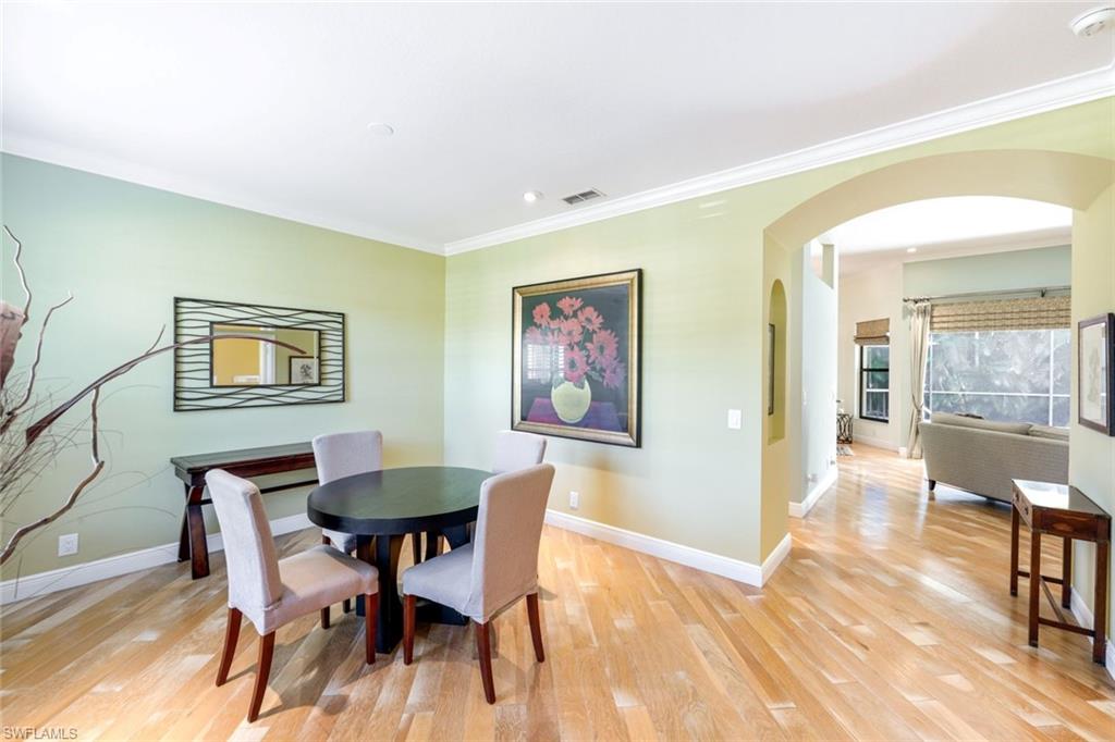 302 Sawgrass Court Naples, FL 34110 - Photo 15 of 40 a view of a dining room with furniture and wooden floor