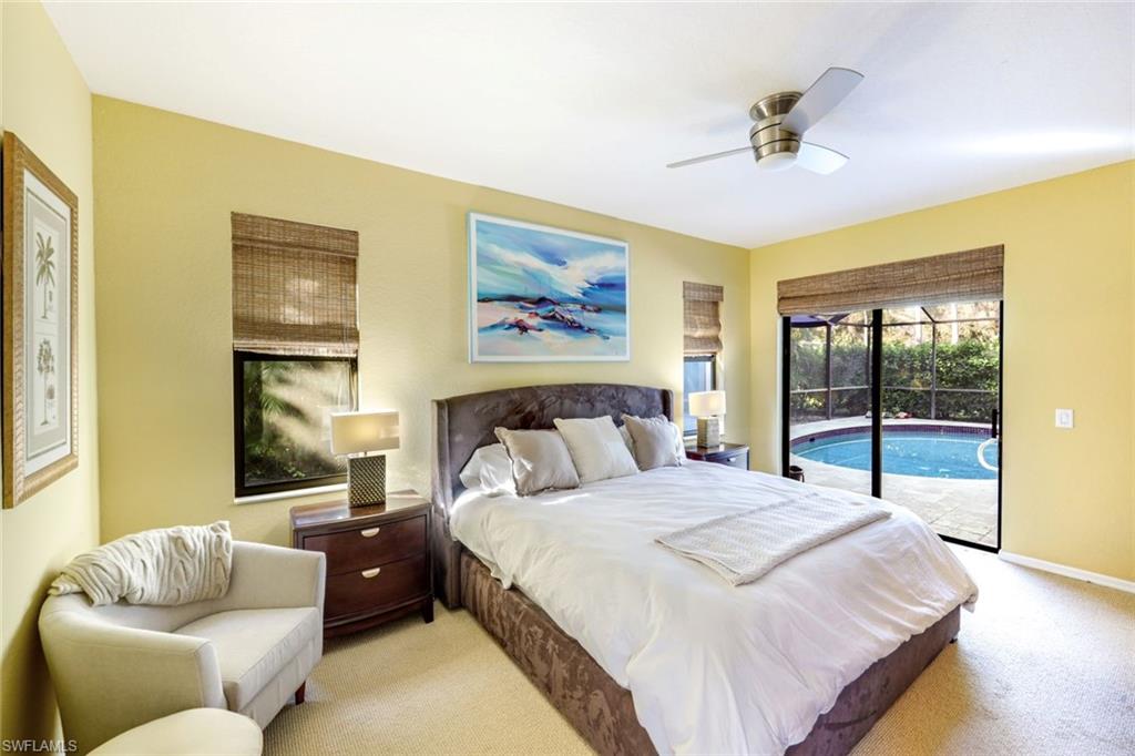 302 Sawgrass Court Naples, FL 34110 - Photo 16 of 40 a bedroom with a bed and glass window