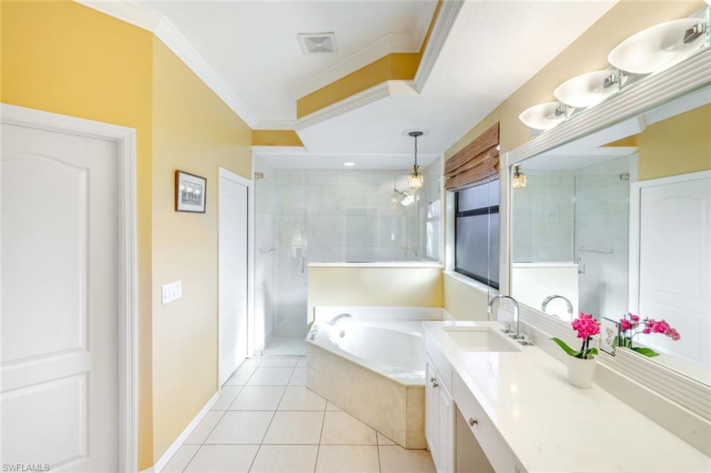 302 Sawgrass Court Naples, FL 34110 - Photo 18 of 40 a bathroom with a sink mirror and a bath tub