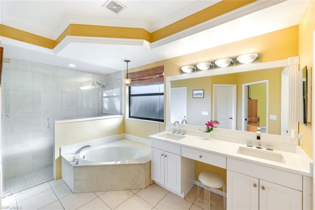 302 Sawgrass Court Naples, FL 34110 - Photo 19 of 40 a bathroom with a tub sink and mirror