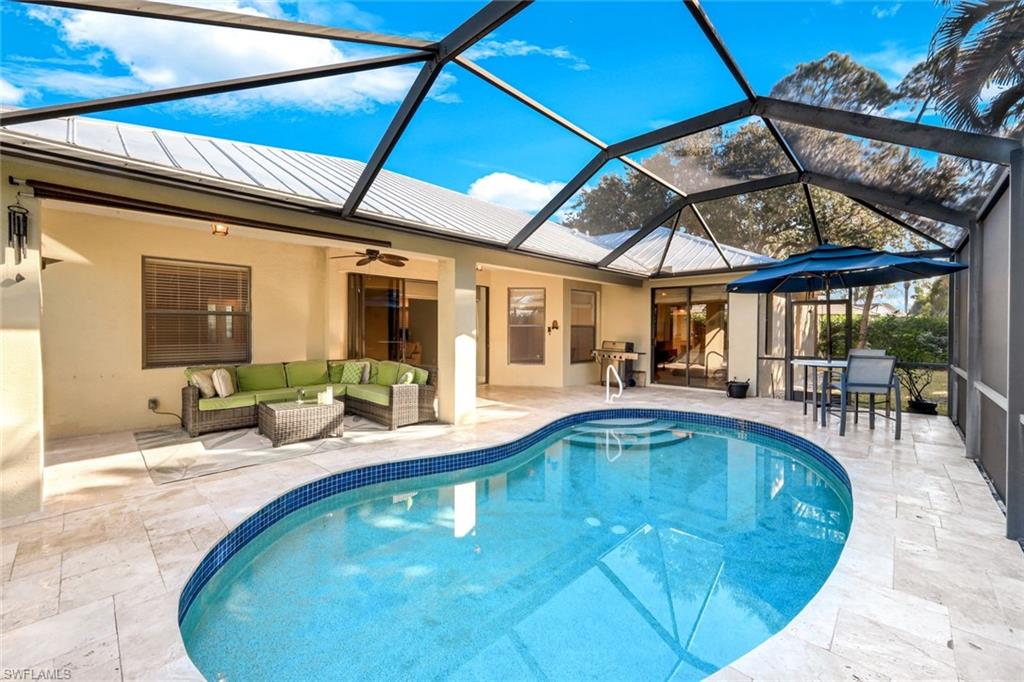 302 Sawgrass Court Naples, FL 34110 - Photo 2 of 40 a view of a swimming pool with a patio