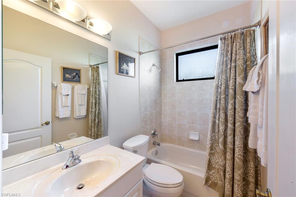 302 Sawgrass Court Naples, FL 34110 - Photo 21 of 40 a bathroom with a bathtub shower sink mirror and toilet