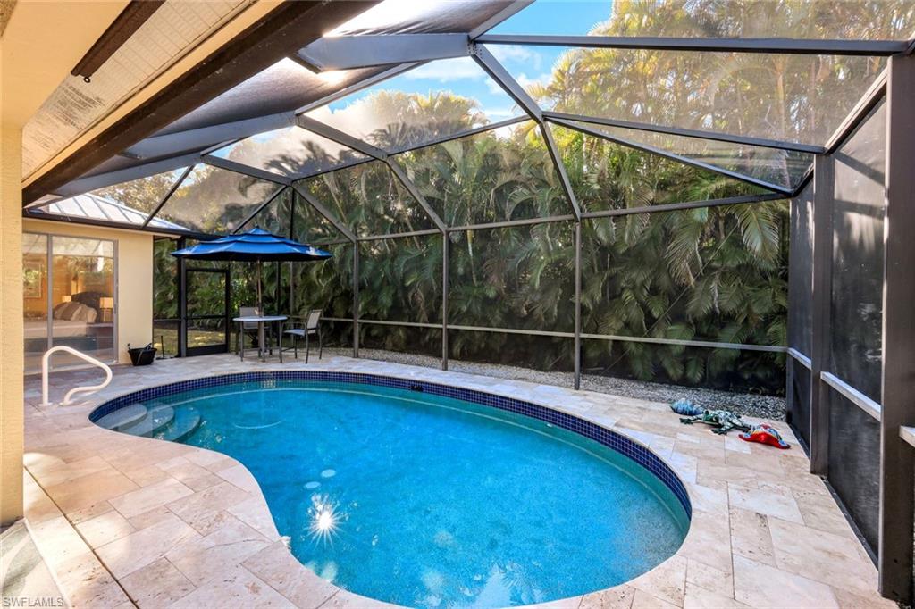 302 Sawgrass Court Naples, FL 34110 - Photo 24 of 40 a view of a swimming pool with a porch