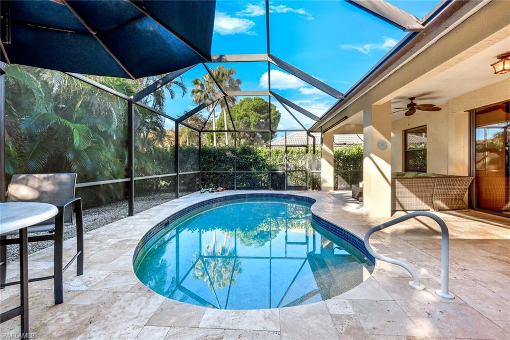 302 Sawgrass Court Naples, FL 34110 - Photo 27 of 40 a view of a swimming pool with a patio