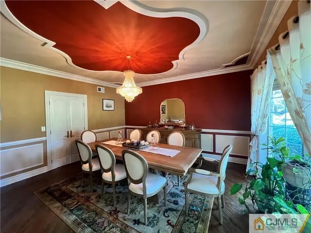 a dining hall with stainless steel appliances kitchen island granite countertop a table and chairs in it