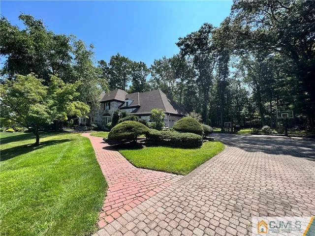a view of a house with a big yard plants and large trees