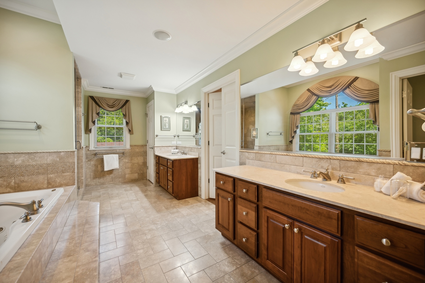 1622 Brandon Road Glenview, IL 60025 - Photo 14 of 31 a spacious bathroom with a double vanity sink a large mirror and a bathtub