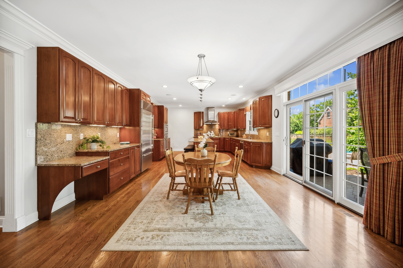1622 Brandon Road Glenview, IL 60025 - Photo 8 of 31 a kitchen with stainless steel appliances granite countertop wooden cabinets a dining table and chairs