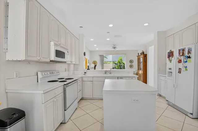 a kitchen with white cabinets and appliances