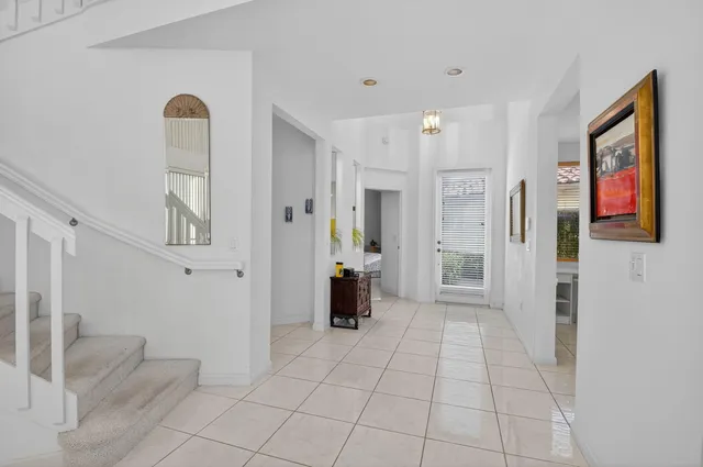 a view of a hallway with bathroom and front door