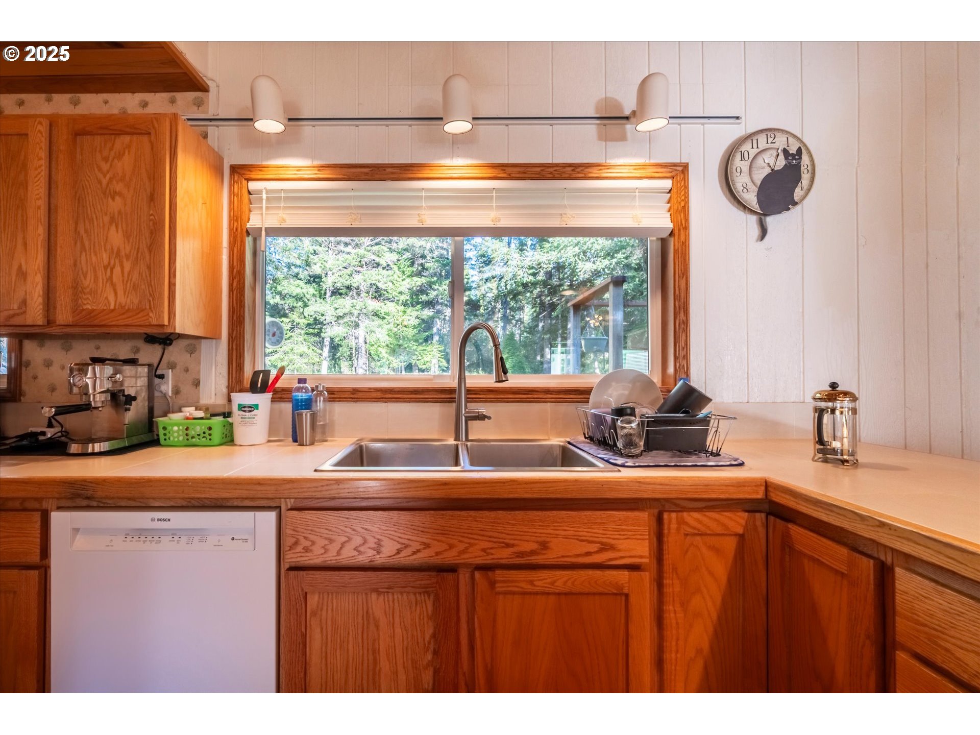 54177 Morrison Road Bandon, OR 97411 - Photo 16 of 47 a kitchen with kitchen island a sink a large window and cabinets