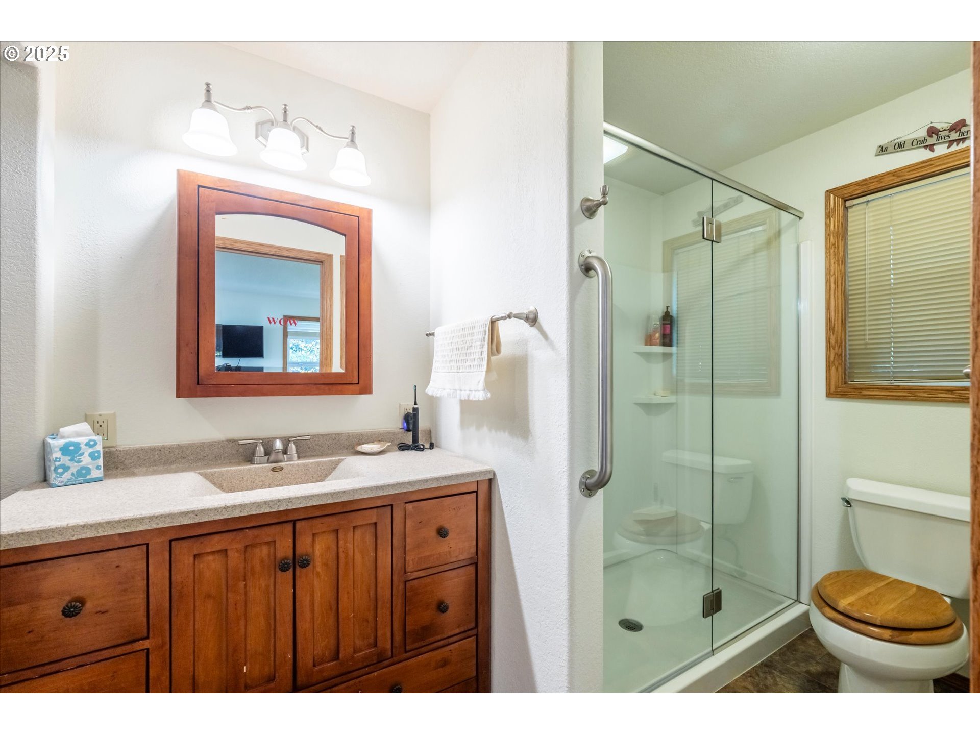 54177 Morrison Road Bandon, OR 97411 - Photo 25 of 47 a bathroom with a shower sink vanity and mirror