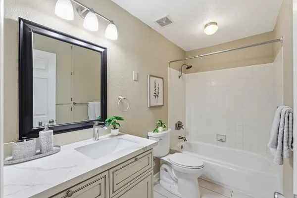 a bathroom with a sink a toilet and shower a mirror