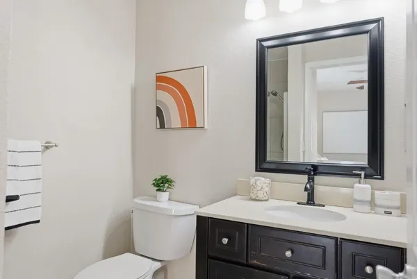 a bathroom with a granite countertop sink mirror and toilet