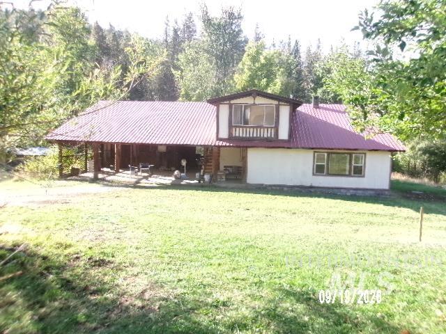 31997 2nd Fork Road Ola, ID 83657 - Photo 4 of 47 Exterior featuring a red corrugated metal roof, white siding, and a covered porch with exposed wood beams