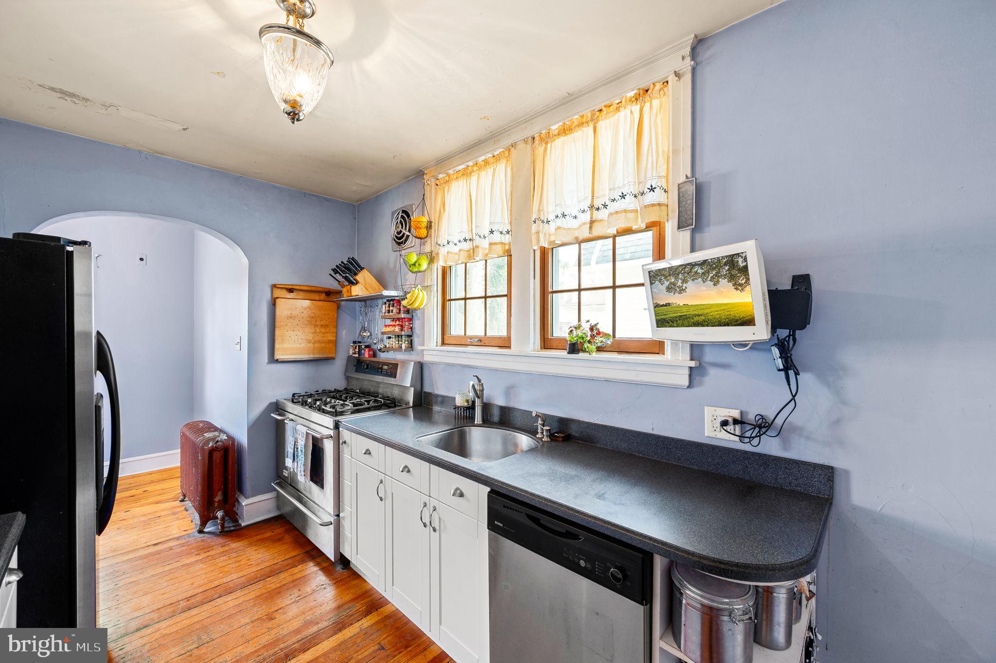 281 Wayne Avenue Lansdowne, PA 19050 - Photo 13 of 28 a kitchen with stainless steel appliances a sink a stove a refrigerator cabinets and a window