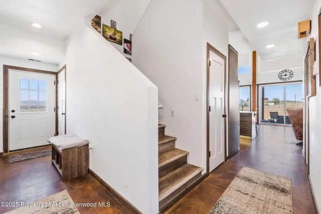 a view of a hallway with wooden floor and staircase