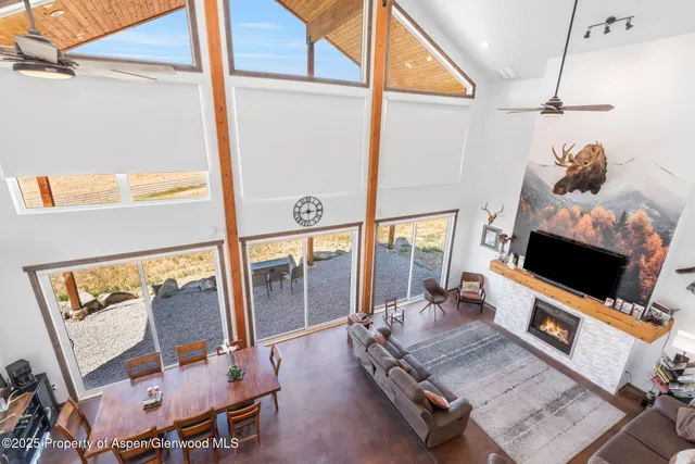 a view of a house with a small yard and large tree