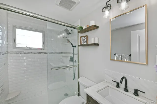 a bathroom with a sink mirror and a shower