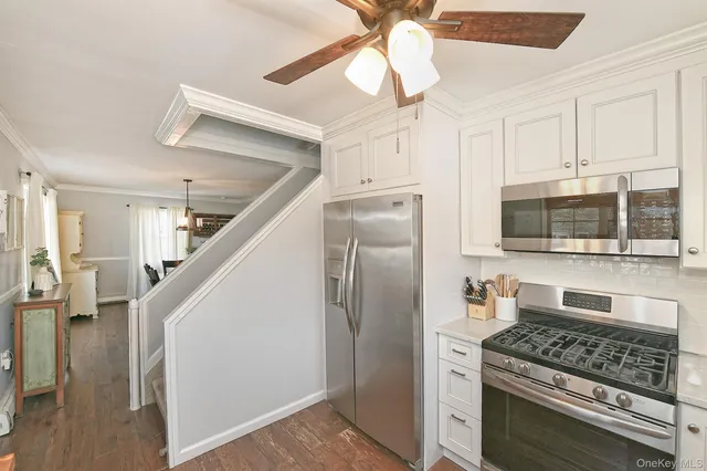 a kitchen with stainless steel appliances granite countertop a refrigerator and a stove top oven