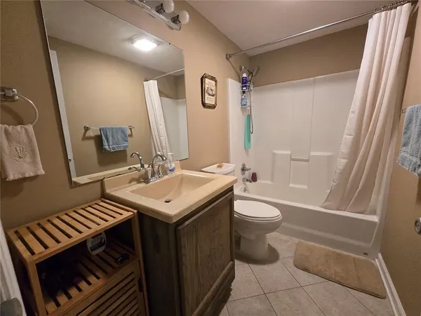 a bathroom with a sink a toilet and shower a mirror