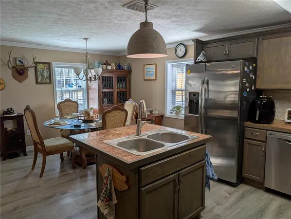 a kitchen with stainless steel appliances granite countertop a sink a stove and refrigerator