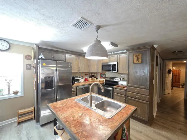 a kitchen with stainless steel appliances granite countertop a sink refrigerator and cabinets