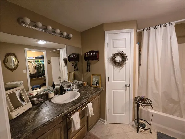 a bathroom with a sink a toilet a mirror and shower