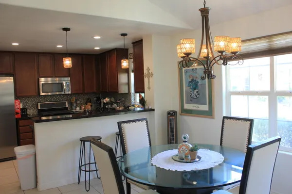 a kitchen with kitchen island granite countertop wooden cabinets a refrigerator a sink and a stove