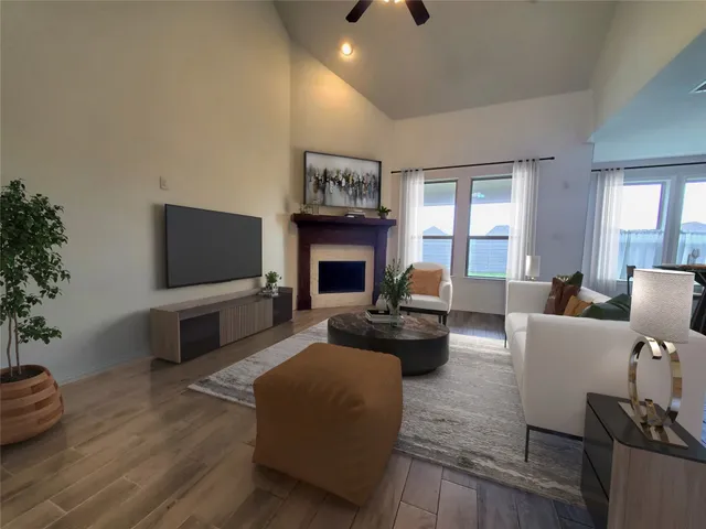 a living room with furniture a flat screen tv and a fireplace