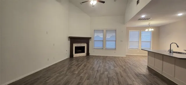 a view of an empty room with a fireplace and wooden floor