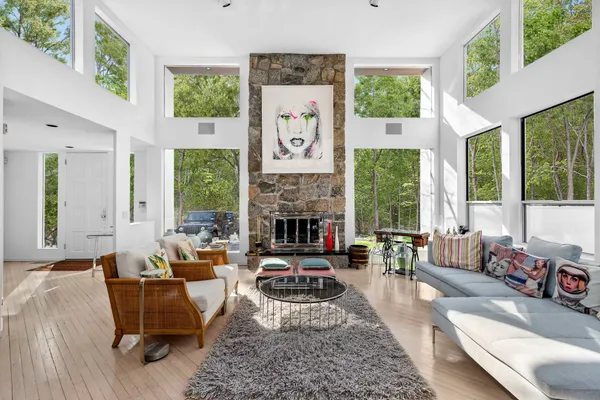 a living room with furniture large window and fireplace