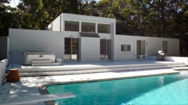 a house view with swimming pool in front of it