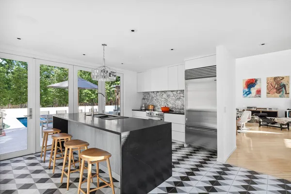 a kitchen with granite countertop a stove a sink and a refrigerator