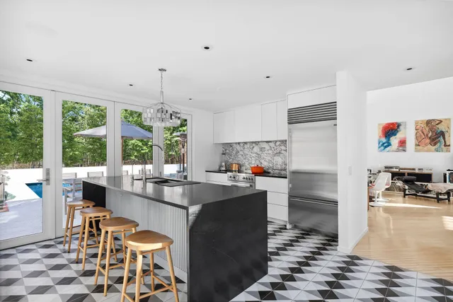 a kitchen with granite countertop a stove a sink and a refrigerator