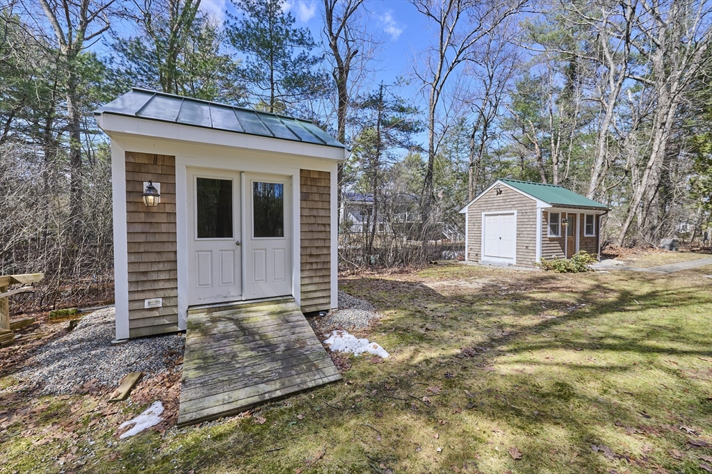 42 Troutbrook Road Dover, MA 02030 - Photo 35 of 36 a backyard of a house with large trees and brick wall