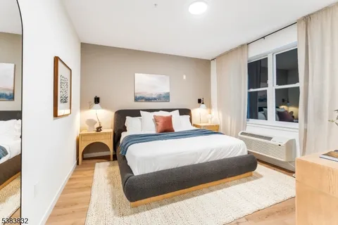 a bedroom with bed and a large window